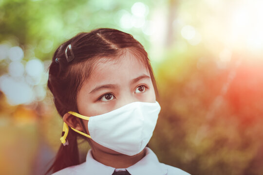 Thai Child Girl Student Wearing Protective Medical Face Mask In School   To Prevent The Outbreak While Back To School ,fighting The Outbreak Of Covid-19 Concept.