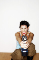 Obraz premium Woman pointing a drill at the camera