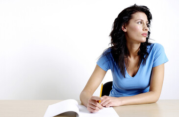 Woman thinking while writing