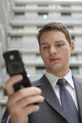 Businessman text messaging on his cell phone