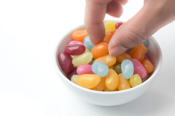 Picking up a jelly bean from bowl of brightly colored candy
