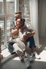 Family near window. Couple at home. Woman in a overalls