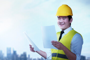 Asian construction worker with hardhat holding planning paper