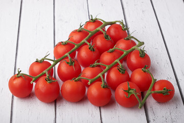 Tomato branch isolated on a wooden background.