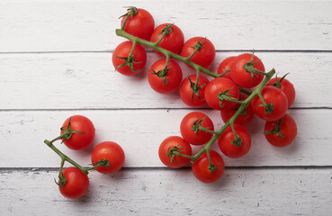 Tomato branch isolated on a wooden background.