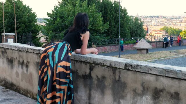 back view of pensive elegant beautiful woman enjoying panorama from Janiculum. 