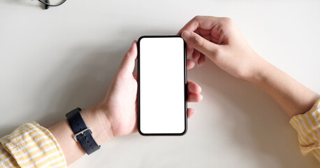 Top view Woman sitting and holding blank screen mock up mobile phone
