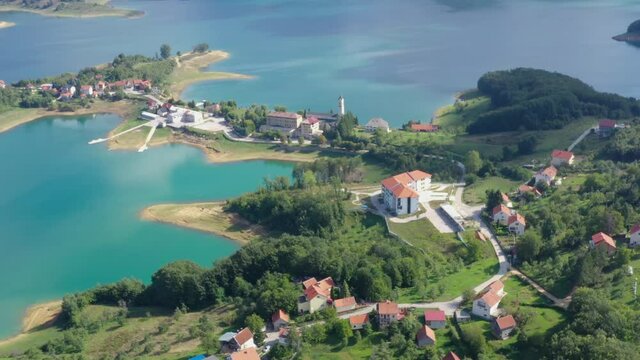 Bosnia and Herzegovina Rama lake with Franjevacki Samostan Monastery and town of Scit, Aerial flyover shot