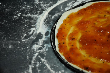 Tomato sauce on top pizza dough. An important trick for making tasty and appetizing pizza is to prepare quality pizza dough and sauces.