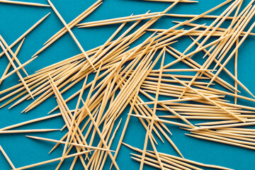 Lots of wooden toothpicks on a blue background. The concept of order and chaos.