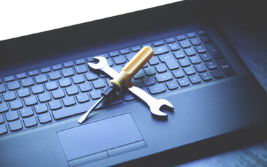 Wrench and screwdriver on the computer keyboard. IT Service. Support