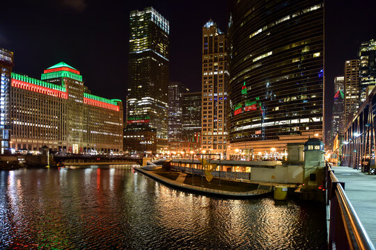 Illuminated Buildings By River At Night