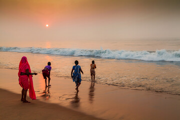 Unidentified pilgrims bathing at Puri Beach as the sunrises.