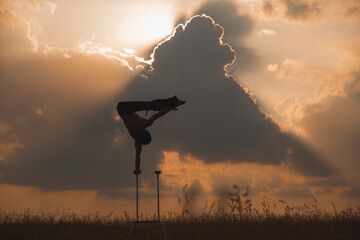 performance of an aerialist outdoors during sunset.
