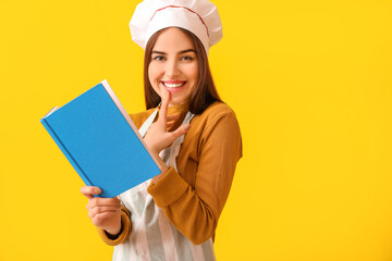 Young woman with recipe book on color background