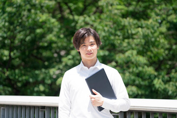 Fototapeta premium ノートパソコンを抱える ビジネスマン 学生 汎用