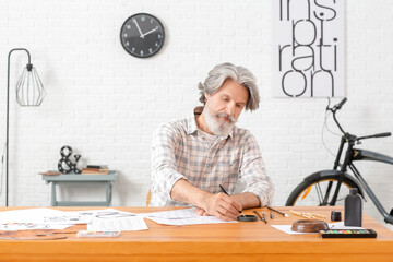 Senior male calligraphist working in office
