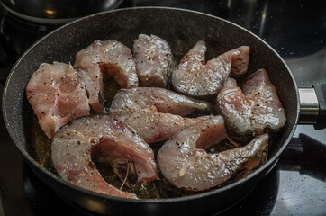 Fish steaks fried in a pan on an induction stove	
