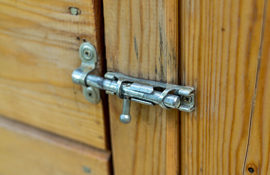 Vintage metal latch for a wooden door.