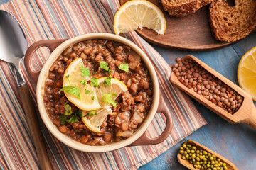 Pot of tasty lentils soup on table