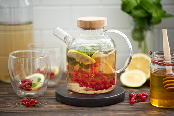 Fototapeta na wymiar berry tea with red currant berries, lemon, mint and honey