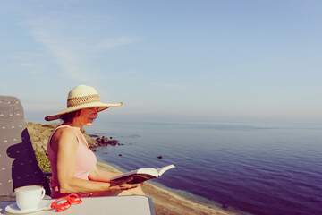 Fototapeta premium Woman on sea read book, relaxing
