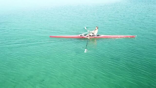 Single scull rowing competitor paddles