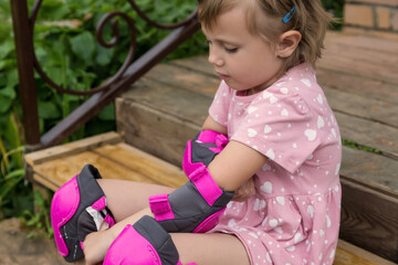 A little girl is wearing protection for roller skating