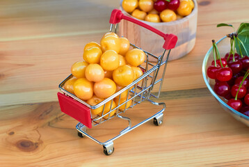 Mini shoppingcart with  ripe cherries.