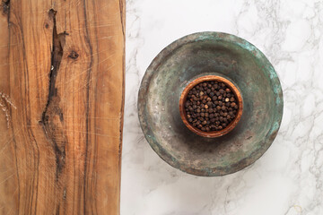 Black pepper and spice concept in wooden bowl