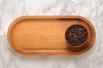 Black pepper on a wooden presentation board