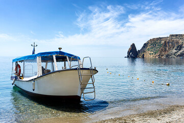 Fototapeta na wymiar A motor boat moored on the shore of Cape Fiolent of the Black Sea in Crimea.
