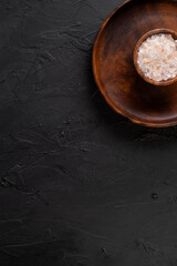 Salt concept with wooden presentation board on black stone floor ( with copy space )