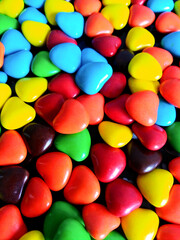 Different colored round candy. Multi-colored glazed sweets in the form of hearts.
