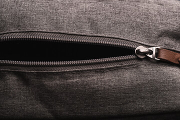 Horizontal opened zippers with metal slider body with leather pull tab of gray cloth bag