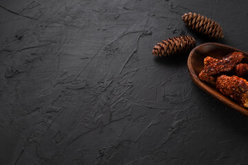 Dried tomatoesconcept with wooden presentation board on black stone floor ( with copy space )