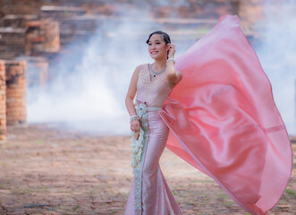 Woman wearing typical thai dress with thai style, Beauty fantasy Thai dress traditional costume on brick in old temple