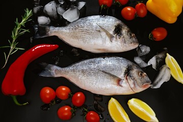 Fish seafood dorado, raw food on black background, cooking.