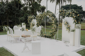 elegant White wedding stage decoration with floral arch gate. outdoor nature wedding concept