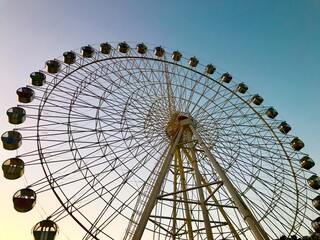 Ferris wheel against blue sky at sunset