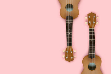 Minimalistic composition made of ukulele guitars on a pastel pink background. Creative layout with...