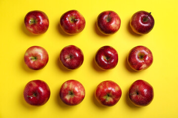Tasty red apples on yellow background, flat lay
