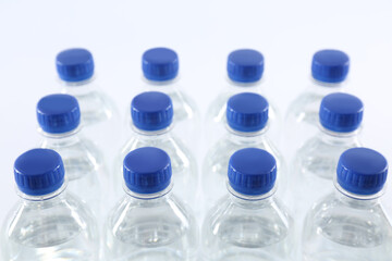 Plastic bottles with pure water on white background, closeup