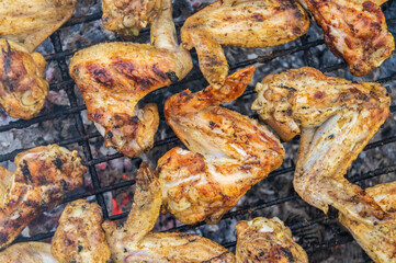 Barbecue chicken fried wings. On coals and grill close-up
