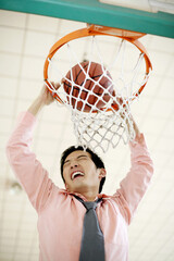 Businessman dunking basketball © ImageHit