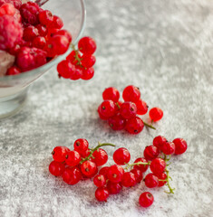 Ice cream in a glass bowl and red summer berries currants and raspberries on a light background; Summer still life, close-up, refreshing treat
