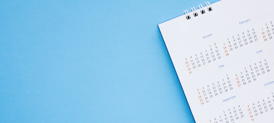 calendar page close up on blue background business planning appointment meeting concept