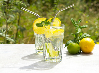 Lemonade. Tall glasses cold drink with lime and lemon
