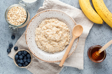 Healthy breakfast oatmeal porridge with fruits, berries and honey. Rolled oats porridge. Clean eating, dieting concept. Vegetarian breakfast food