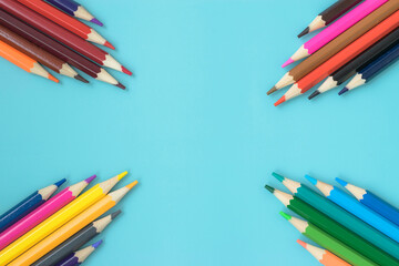 Composition of lined colored pencils on a turquoise background. School office. Colored pencils laid out vertically